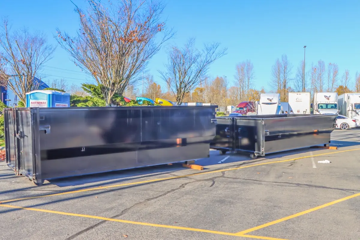 Professional dumpster rental service with roll-off container on residential driveway in Harvest